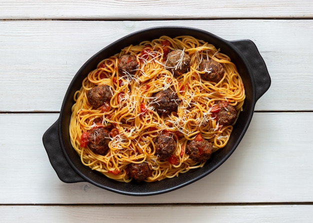 Polpette con spaghetti, salsa di pomodoro e parmigiano. Cucina italiana.