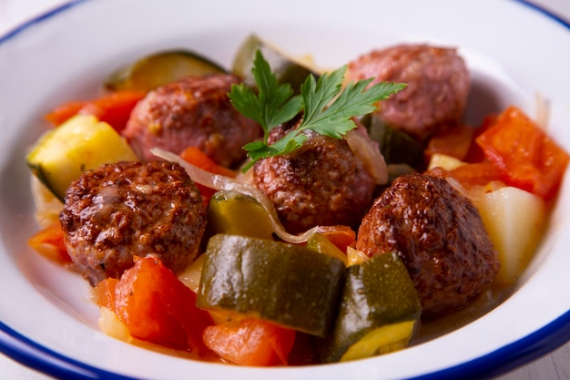 Polpette cotte con verdure al forno assortite.