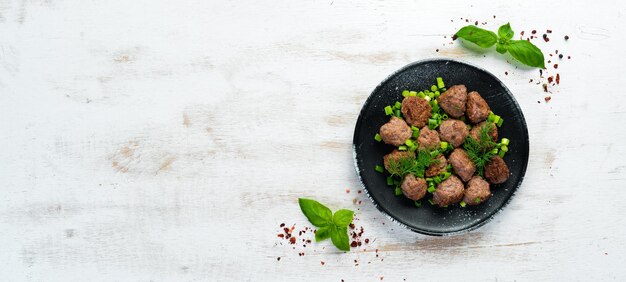 Polpette di carne al forno con cipolle su un piatto nero Vista dall'alto Spazio di copia gratuito