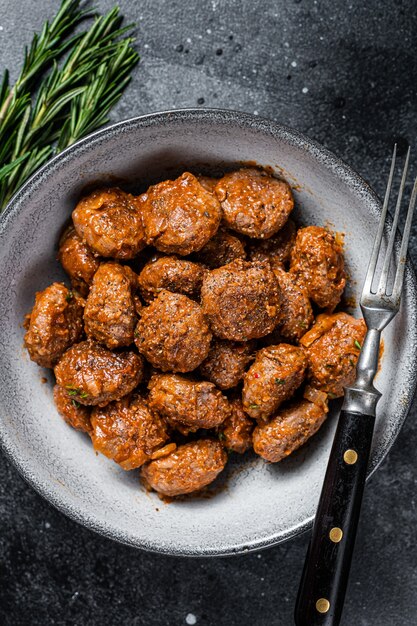 Polpette di carne arrosto in salsa di pomodoro di carne macinata di manzo e carne di maiale al rosmarino. Sfondo nero. Vista dall'alto.