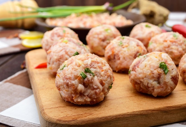 Polpette di carne cruda pronte per la cottura su un tagliere Primo piano