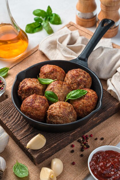 Polpette di carne fritte con basilico fresco su fondo grigio