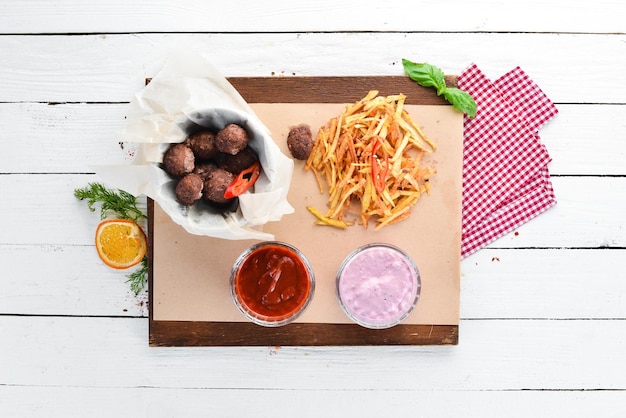 Polpette di carne fritte con patatine fritte e ketchup su sfondo di legno Vista dall'alto Spazio libero per il testo