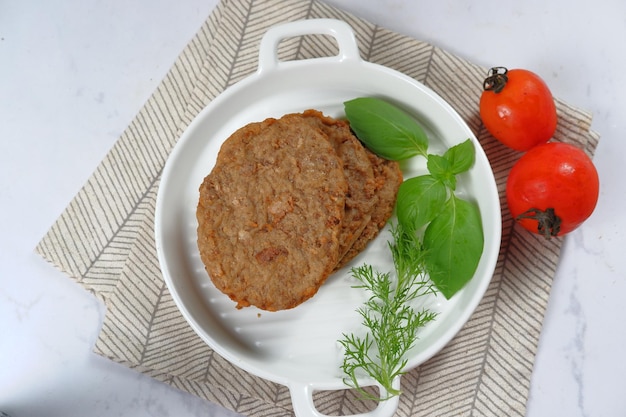 polpette di carne hamburger con verdure su sfondo bianco.