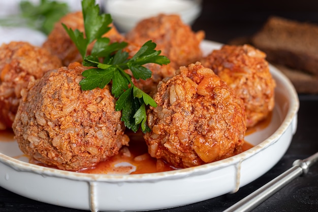 Polpette di carne su fondo in legno con foglie di salvia e prezzemolo. Pranzo fatto in casa.