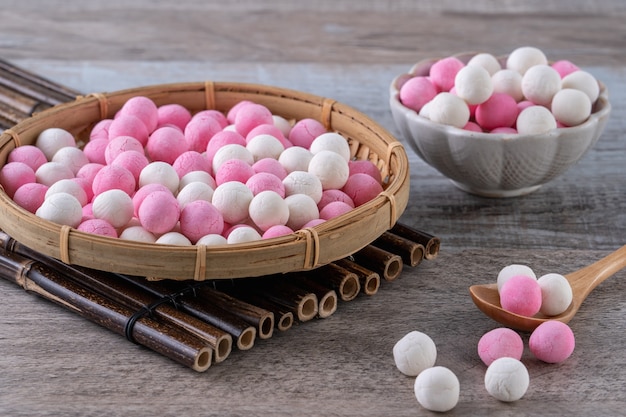 Polpette di gnocco di riso glutinoso tangyuan bianco e rosso crudo sulla tavola di legno