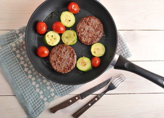 Polpette di manzo alla griglia con zucchine e pomodorini in padella