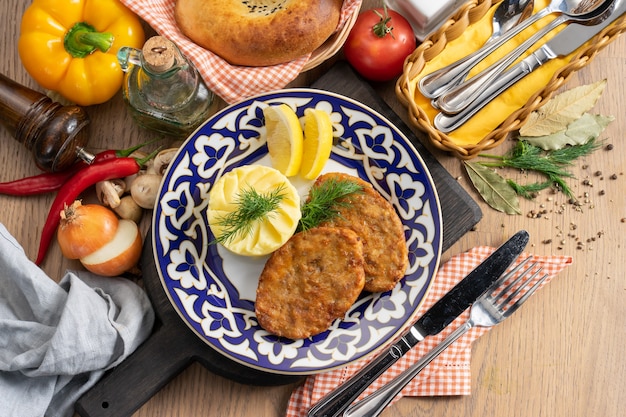 Polpette di manzo con purè di patate, limone e aneto in un piatto con un tradizionale uzbeko