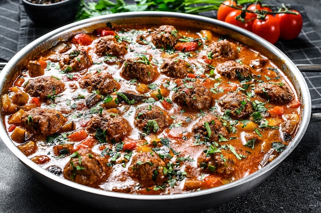 Polpette di manzo con salsa di pomodoro e verdure in padella