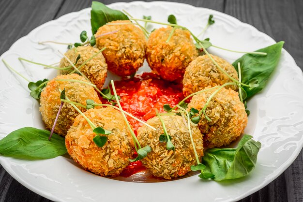 Polpette fritte con le verdure e la salsa sul piatto