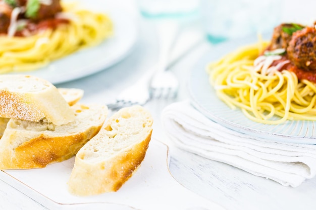 Polpette italiane fatte in casa guarnite con coriandolo e parmigiano su spaghetti per cena.