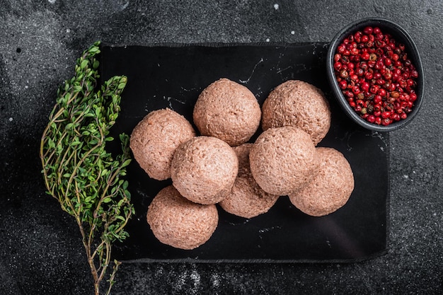 Polpette vegane crude da carne a base vegetale con timo Sfondo nero Vista dall'alto