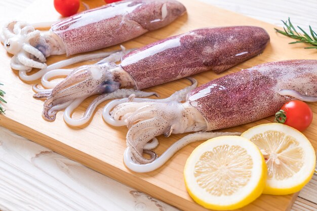 polpo fresco o calamari crudi su tavola di legno