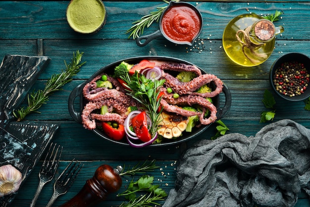 Polpo grande bollito con verdure grigliate in una lastra di pietra nera Frutti di mare Vista dall'alto Spazio libero per il testo