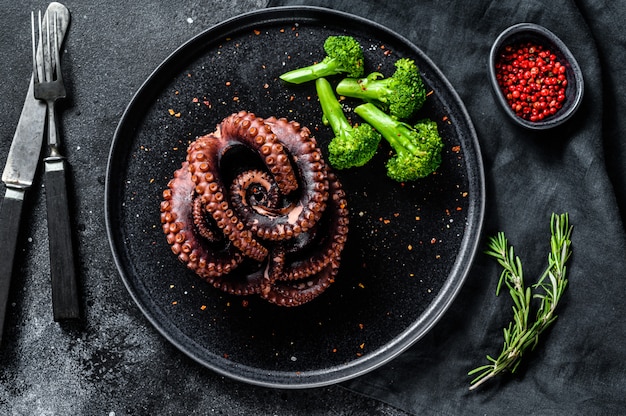 Polpo intero alla griglia con broccoli su un piatto. Vista dall'alto