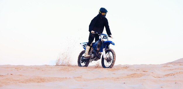 Polvere del deserto o atleta alla guida di una motocicletta per azione, avventura o fitness con prestazioni o adrenalina Sport sulla sabbia o persona in moto sulle dune per esercizi di allenamento, gare o sfide