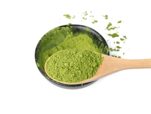 Polvere del tè verde di Matcha in cucchiaio di legno su bianco