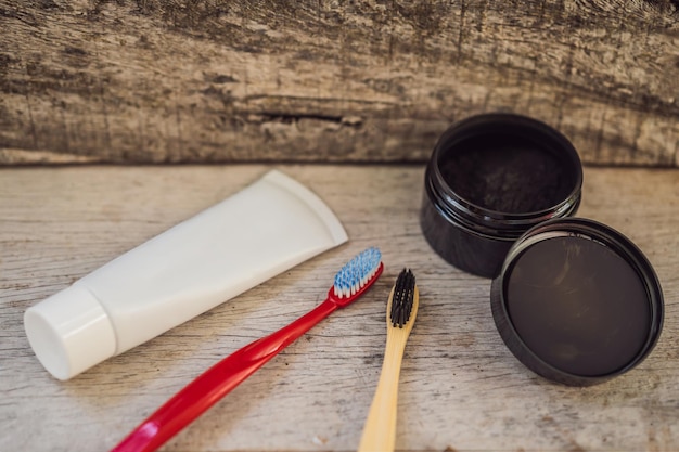 Polvere di carbone attivo VS spazzolino e dentifricio in plastica per spazzolare e sbiancare i denti Spazzolino ecologico in bambù