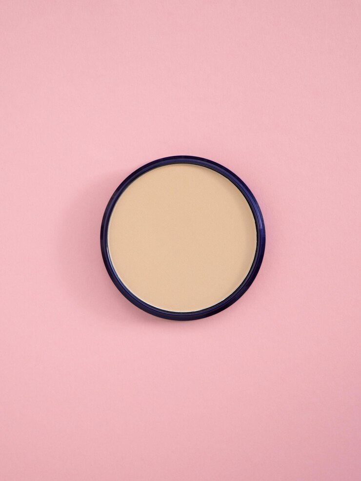 Polvere di concealer facciale beige Vista superiore di polvere per viso nudo in scatola rotonda su sfondo di carta rosa Prodotto di trucco cosmetico di moda Bronzer e consistenza di concealer per una carnagione perfetta Spazio di copia