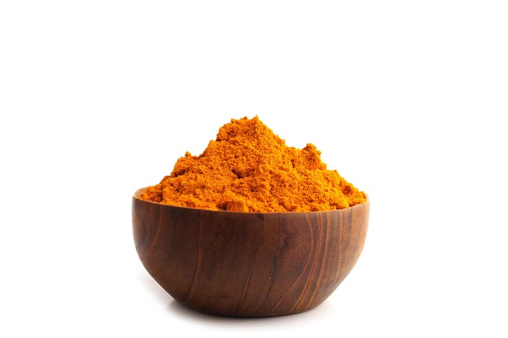 Polvere di curcuma (Curcuma) in ciotole di legno su sfondo bianco, a base di erbe