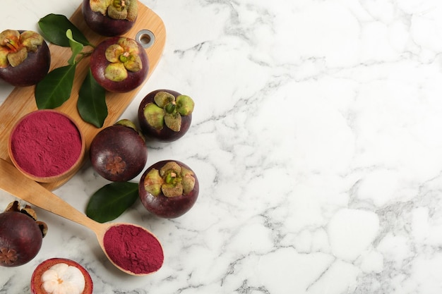 Polvere di mangostano viola e frutta su tavolo di marmo bianco piatto Disposizione dello spazio per il testo