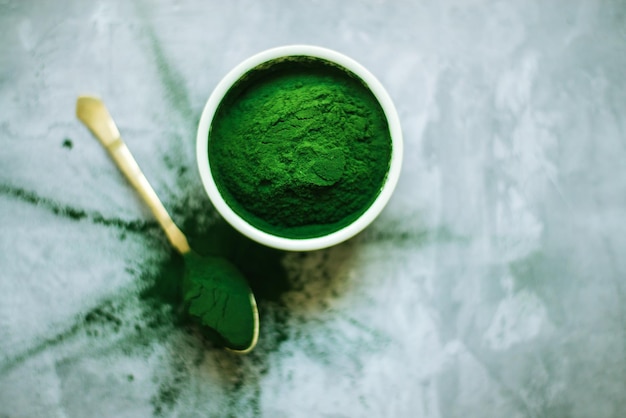 polvere di spirulina in lastre bianche e sparse su fondo di cemento