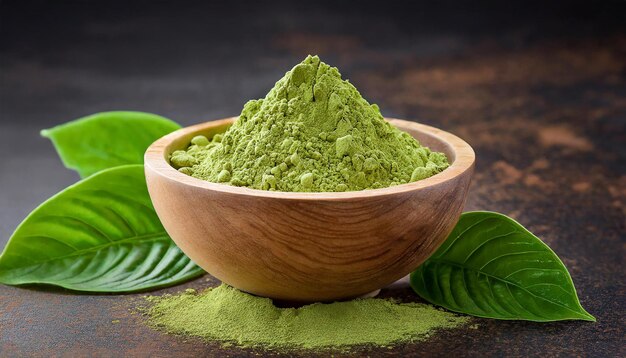 Polvere di tè verde matcha istantaneo in una ciotola di legno con le foglie sul tavolo