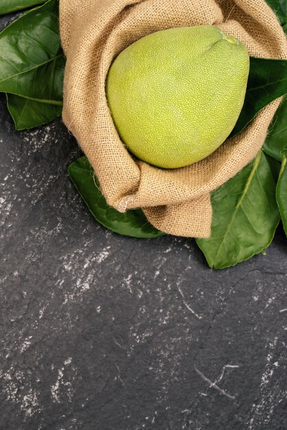 Pomelo sbucciato fresco, pummelo, pompelmo, shaddock su sfondo scuro in cesto di bambù. Frutta di stagione autunnale, vista dall'alto, piatto, colpo da tavolo.