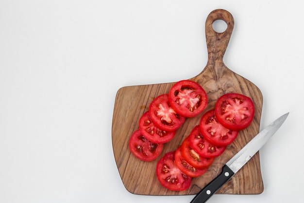 Pomodori a fette isolati su una tavola di legno, vista dall'alto