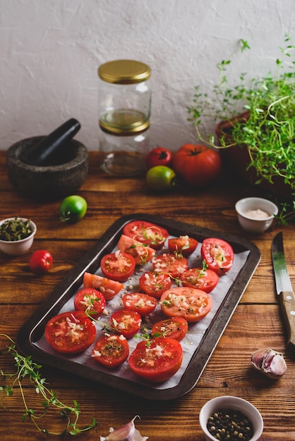 Pomodori affettati con timo e aglio su una teglia