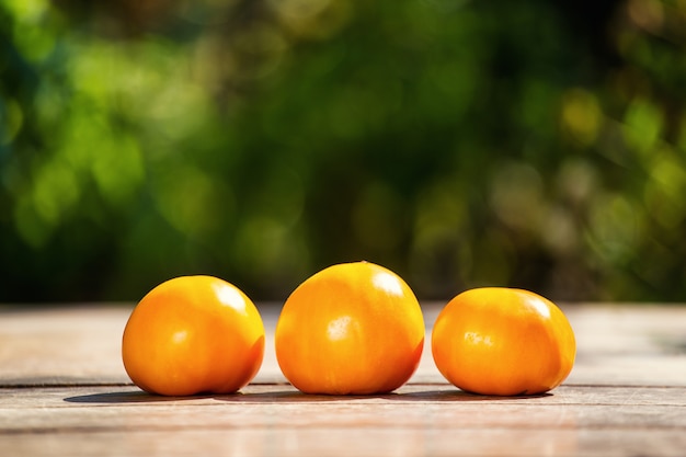 Pomodori arancioni sul tavolo su uno sfondo verde