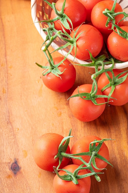 Pomodori bellissimi dettagli di pomodori rossi freschi sui rami su legno rustico vista dall'alto