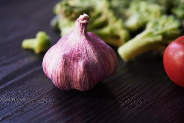 Pomodori broccoli e aglio sdraiato su uno sfondo scuro Alimentazione sana Vegetarianismo Vitamine fresche