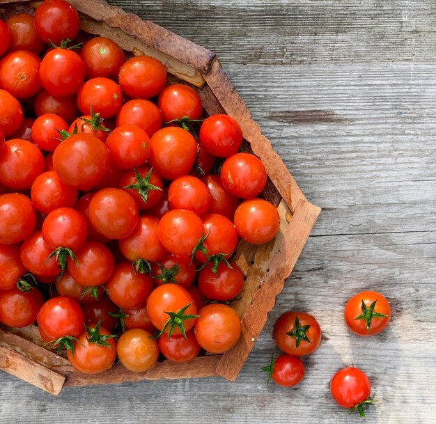 Pomodori ciliegia freschi su fondo di legno