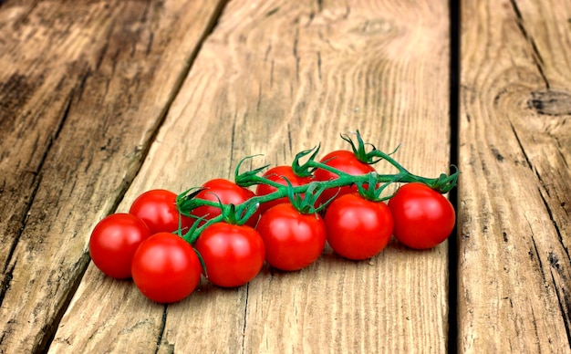 Pomodori ciliegia maturi freschi su vecchio fondo di legno.