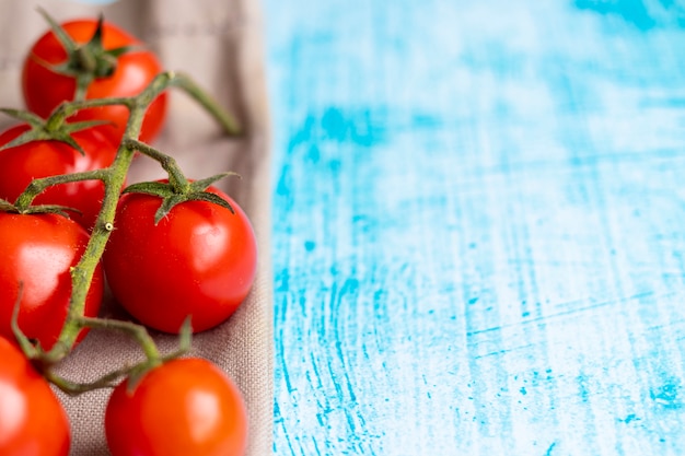 Pomodori ciliegia sul fondo blu di pennellata