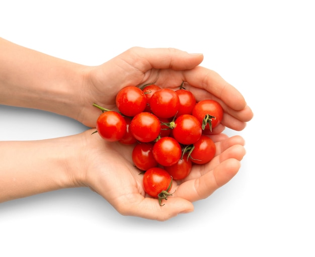 Pomodori ciliegini in mani su uno sfondo bianco primo piano vista dall'alto