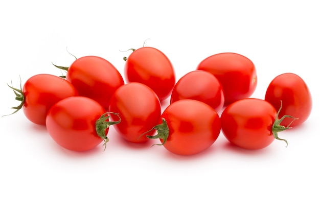 Pomodori ciliegini. Tre pomodorini su un tavolo bianco.