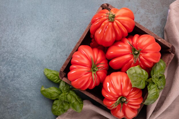 Pomodori coeur con foglia di basilico, primi piani.