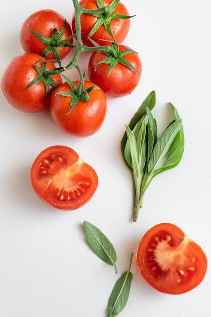 pomodori crudi ed erbe selvatiche su sfondo bianco