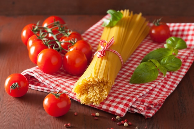 Pomodori di basilico crudo della pasta degli spaghetti. cucina italiana in cucina rustica