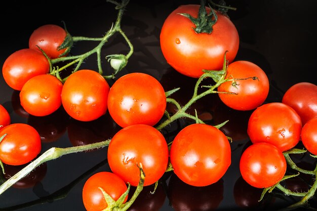 Pomodori di ciliegia freschi su priorità bassa nera.