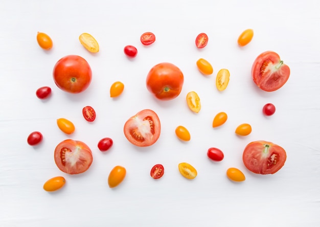 pomodori di varietà su fondo di legno bianco