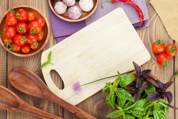 Pomodori e basilico freschi degli agricoltori sulla tavola di legno