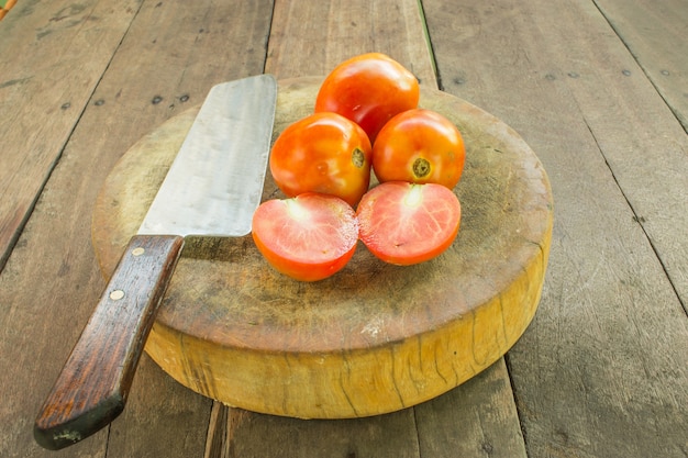 Pomodori e coltelli sono posti sul tavolo.