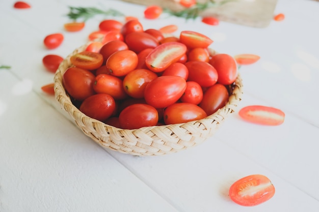 Pomodori e rosmarino freschi su una priorità bassa bianca.