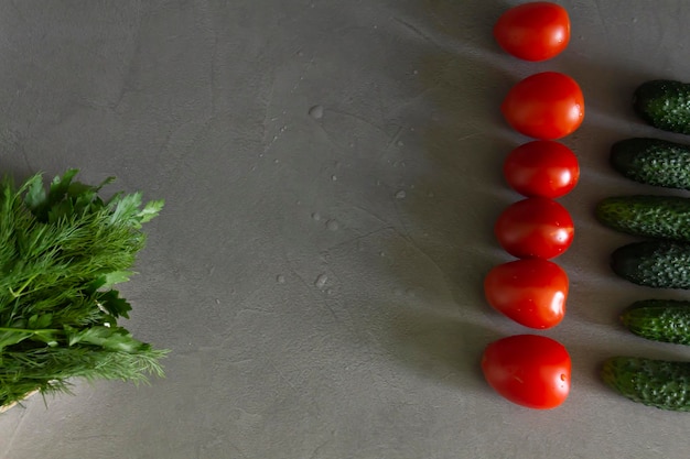 Pomodori freschi cetrioli verdi e fragrante insalata di verdure in un cesto di bambù disposto esattamente in fila sul tavolo della cucina