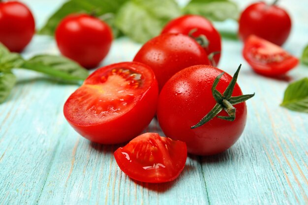 Pomodori freschi con basilico sulla tavola di legno si chiuda