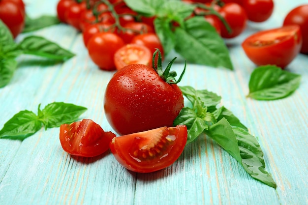 Pomodori freschi con basilico sulla tavola di legno si chiuda