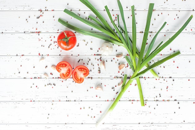 Pomodori freschi con spezie. Alimento sano organico su aglio verde di legno. Verdure estive e autunnali.